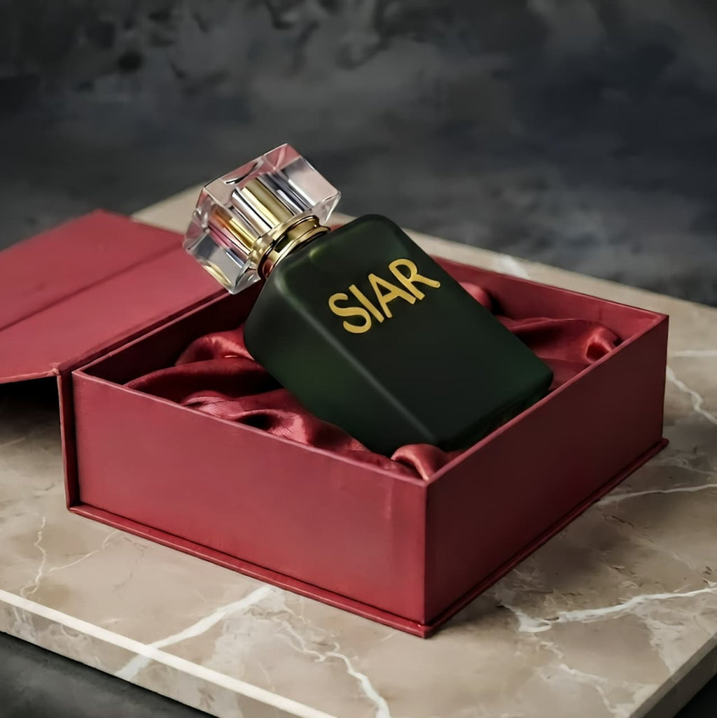 SIAR Noir perfume bottle lying inside box, showcasing sleek black design and elegant packaging by Siar Official.